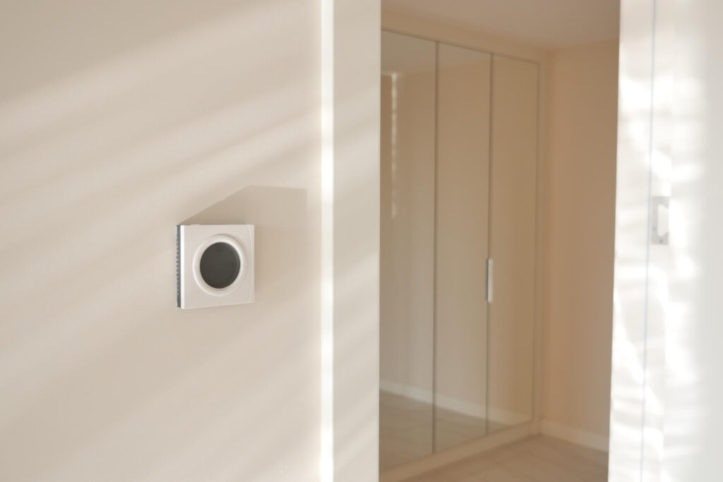 Modern smart home interior featuring a sleek, wall-mounted methane gas detector near a hallway entrance.