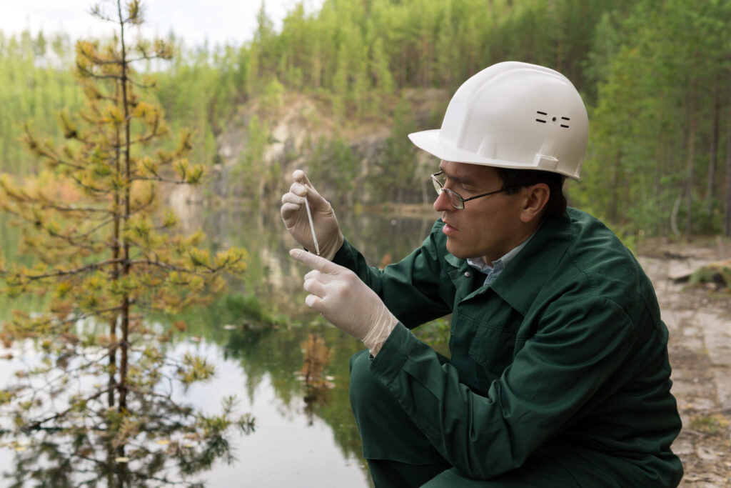 Environmental scientist collecting a water sample near a quarry as part of Fugitive Methane Detection and environmental monitoring efforts.